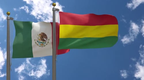 Waving Flags of Mexico and Bolivia Against Blue Sky
