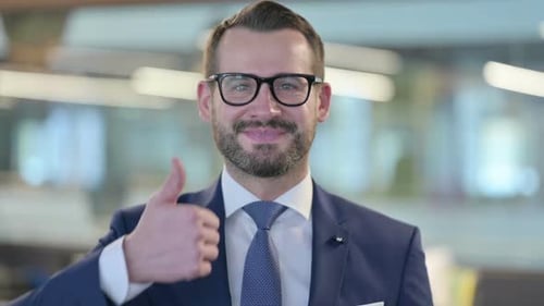 Smiling Man in Suit Gives Thumbs Up