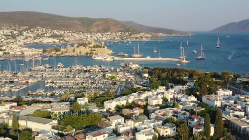 Luftdrohne enthüllt die Küstenstadt Bodrum mit einer Burg und einem Yachthafen voller Segelboote in der