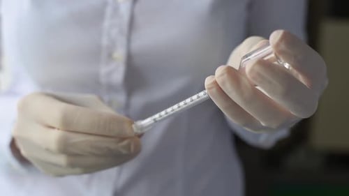 Medical Professional Fills Syringe with Vaccine