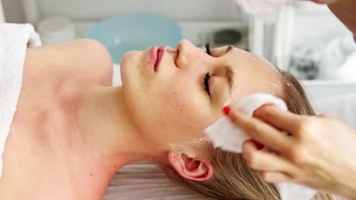 Aesthetician Cleanses Woman's Face in Brightly Lit Room