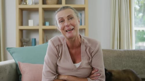 Portrait d'une femme caucasienne senior heureuse assise et faisant un appel vidéo avec chat dans le salon