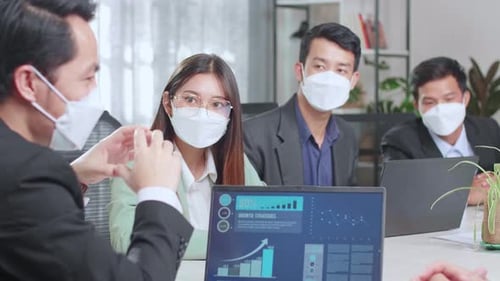 Business Team Meeting With Data Presentation On Laptop