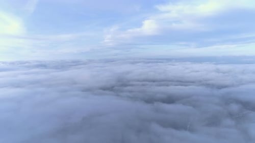 Weiße Wolken bewegen sich im Winter über dem Wald, der mit Nebel bedeckt ist