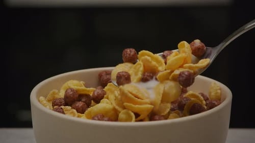 Bowl of Cereal with Milk Being Stirred