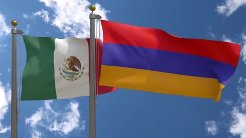 Flags of Mexico and Armenia Waving Against a Clear Blue Sky
