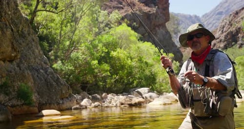 Fisherman fly fishing in river