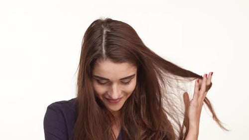 Young Woman Smiles and Plays With Her Hair