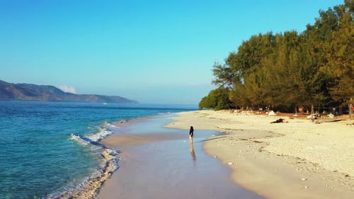 Modern fun woman on holiday enjoying life at the beach on sunny blue and white sand background 4K