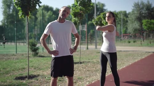 Couple Stretching Before Exercise in Outdoor Park
