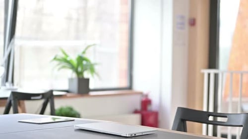 Man Opens Laptop and Types in Workplace