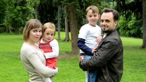 Family (Middle Couple in Love, Cute Girl and Small Boy) Turn To Camera and Smile To Camera in Park
