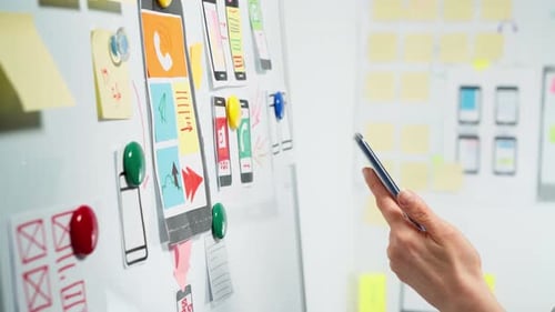 Web designers develop app sketches with a smartphone.