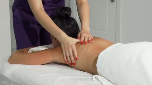 Woman Receiving Massage in Brightly Lit Spa Room