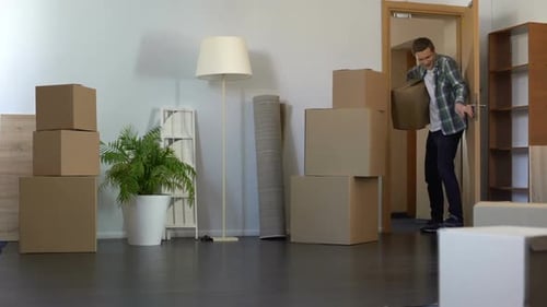 Cheerful Guy Coming With Paper Box to His New Rented Apartment, Real Estate