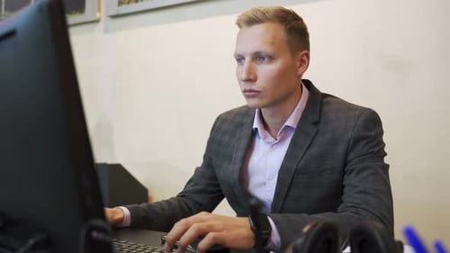 Portrait of Young Man Sitting at His Desk in the Office