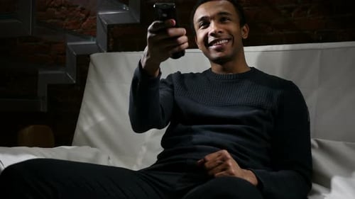 Smiling Man on Couch with Remote Control