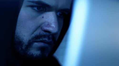 Hackers Gesicht, tippt nachts schnell auf dem Computer