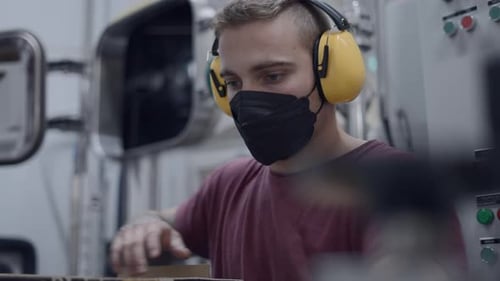 Young Adult Working in Modern Factory with PPE