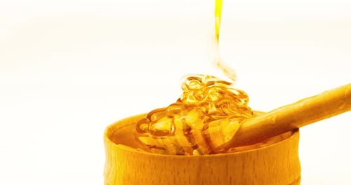 Honey Being Poured into Bowl with Dipper