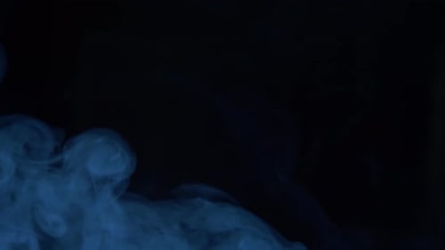 Abstract blue smoke swirling on dark background