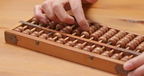 Hands Calculating on Vintage Wooden Abacus