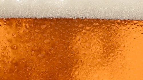 Close up background of beer with bubbles in glass
