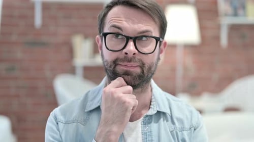 Porträt eines jungen Bartmannes, der über kreative Idee nachdenkt