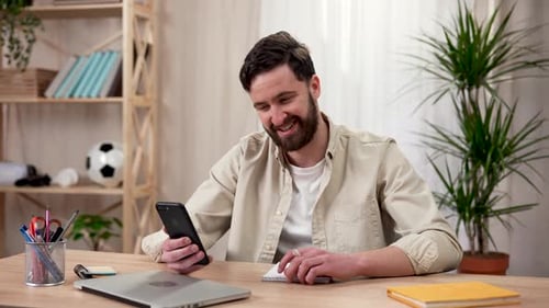 Man On Phone Video Call At Desk Inside