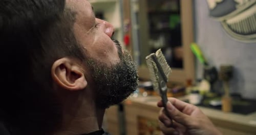 Handsome Man in a Barbershop Shaves His Beard in a Hair Studio