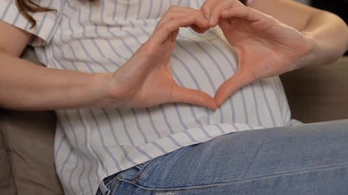 Pregnant Person Making Heart Shape With Hands