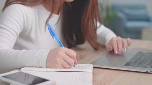 Close Up Girl Typing On Laptop Keyboard And Writing On Notebook