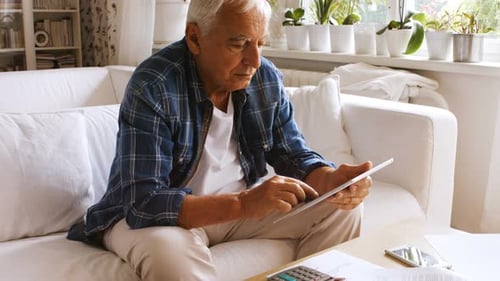 Senior Man Using Tablet on Couch at Home