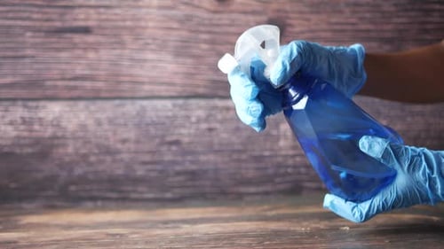 Spraying Sanitizer from Blue Spray Bottle