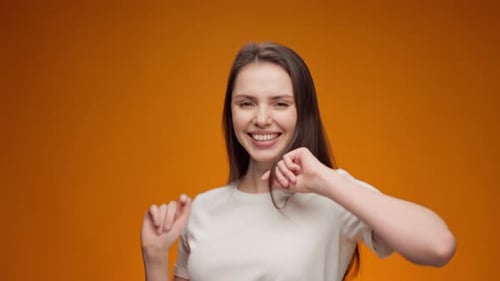 Smiling Brunette Woman Posing Against Orange Background
