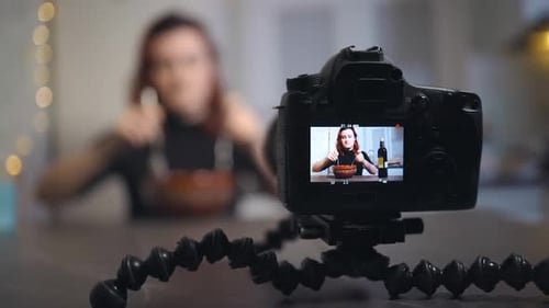 Vista de pantalla Joven bloguera revuelve ensalada mientras graba un tutorial