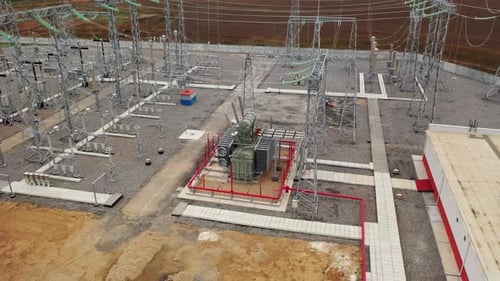 Transformer at the Power Station with Metal Towers and Power Lines Around It