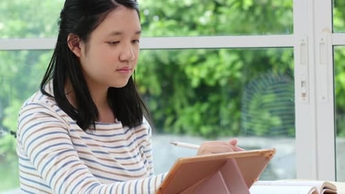 Young Adult Studying with Tablet at Home