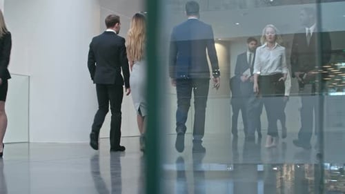 Businesswomen and Businessmen Walking through Hall