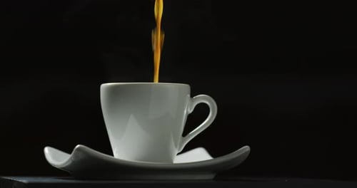 Pouring Stream of Coffee into White Cup