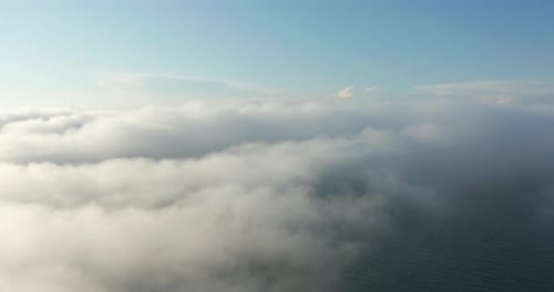 Aerial View of Sea Through Clouds on Sunny Day