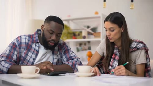 Mixed-Race Couple Planning Family Budget, Counting Incomes and Expenses, Finance