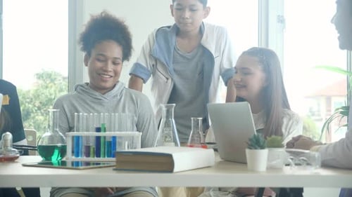 Teacher teaching group student about science and explaining chemical for liquid at lab school.
