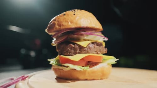 Hamburger Being Assembled on Wooden Cutting Board