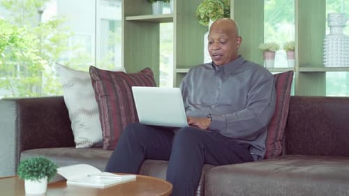 Man Working on Laptop in Living Room