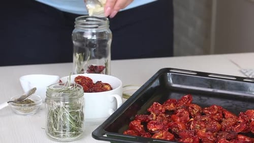 Woman Preparing Sun-Dried Tomatoes with Garlic and Herbs