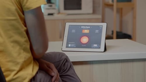 Person Using Tablet to Control Kitchen Lights