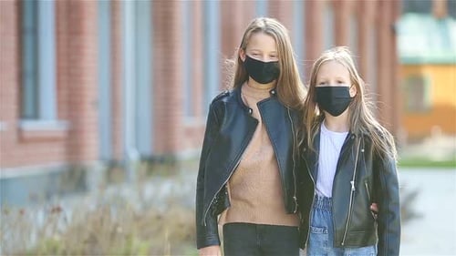 Girls Wearing a Mask on a Background of a Modern Building