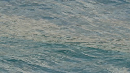 Blue water waves surface, beautiful background with copy space. Small ripples close-up.