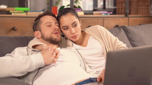 Young Couple Relaxing at Home with Laptop